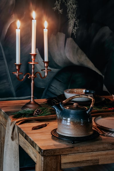 棕色木桌上的蓝色陶瓷茶壶